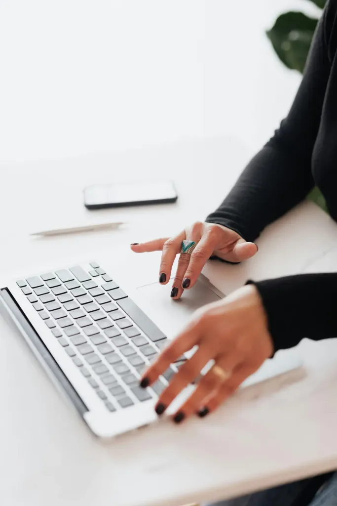 Woman’s hands typing on laptop during project manager hiring process