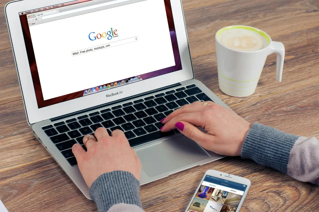 Woman's hands on laptop with Google browser, checking for fake software development reviews